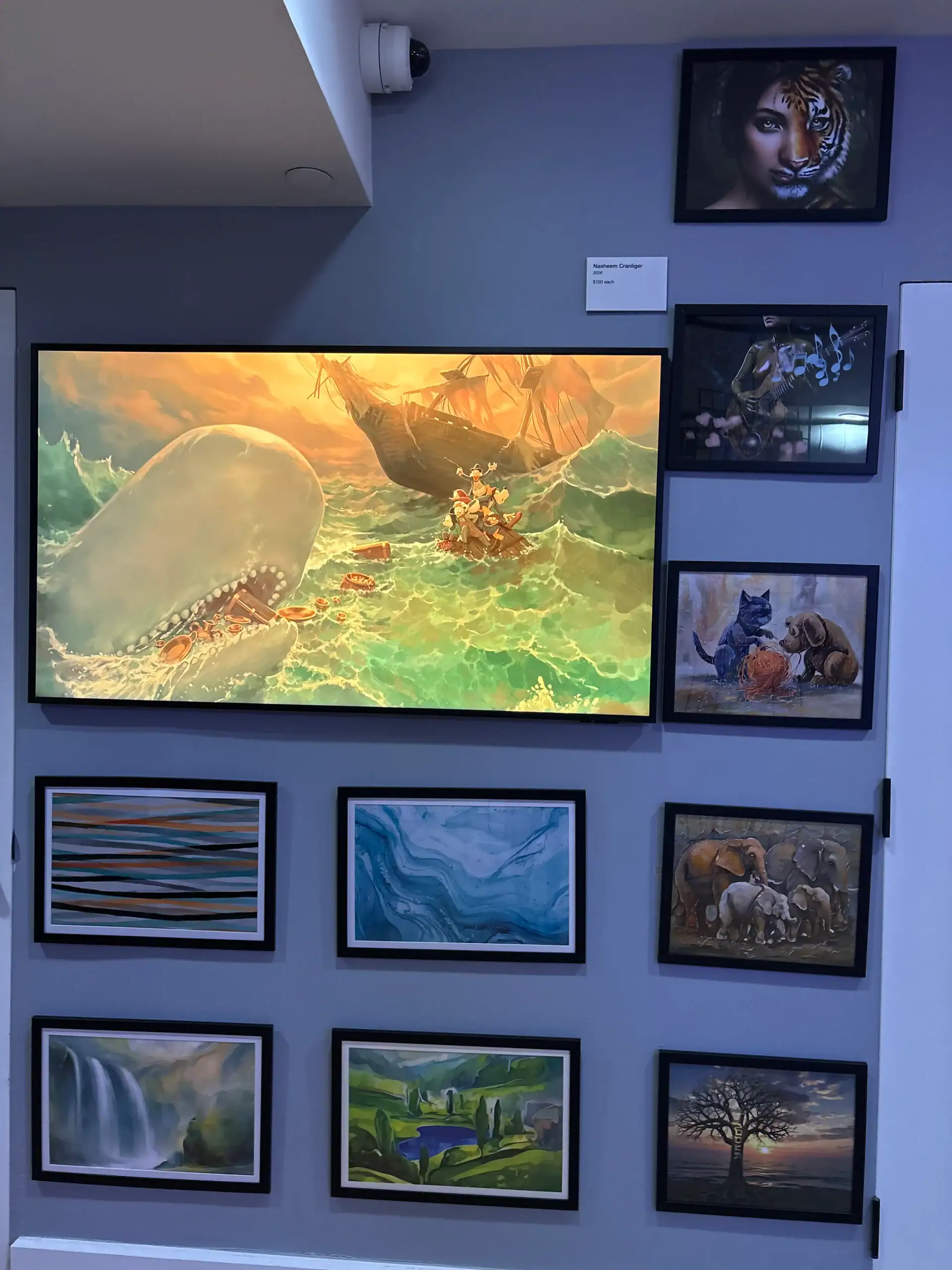 A wall at this NYC Wine Bar & Art Gallery features framed art of animals, landscapes, a ship, and whale.