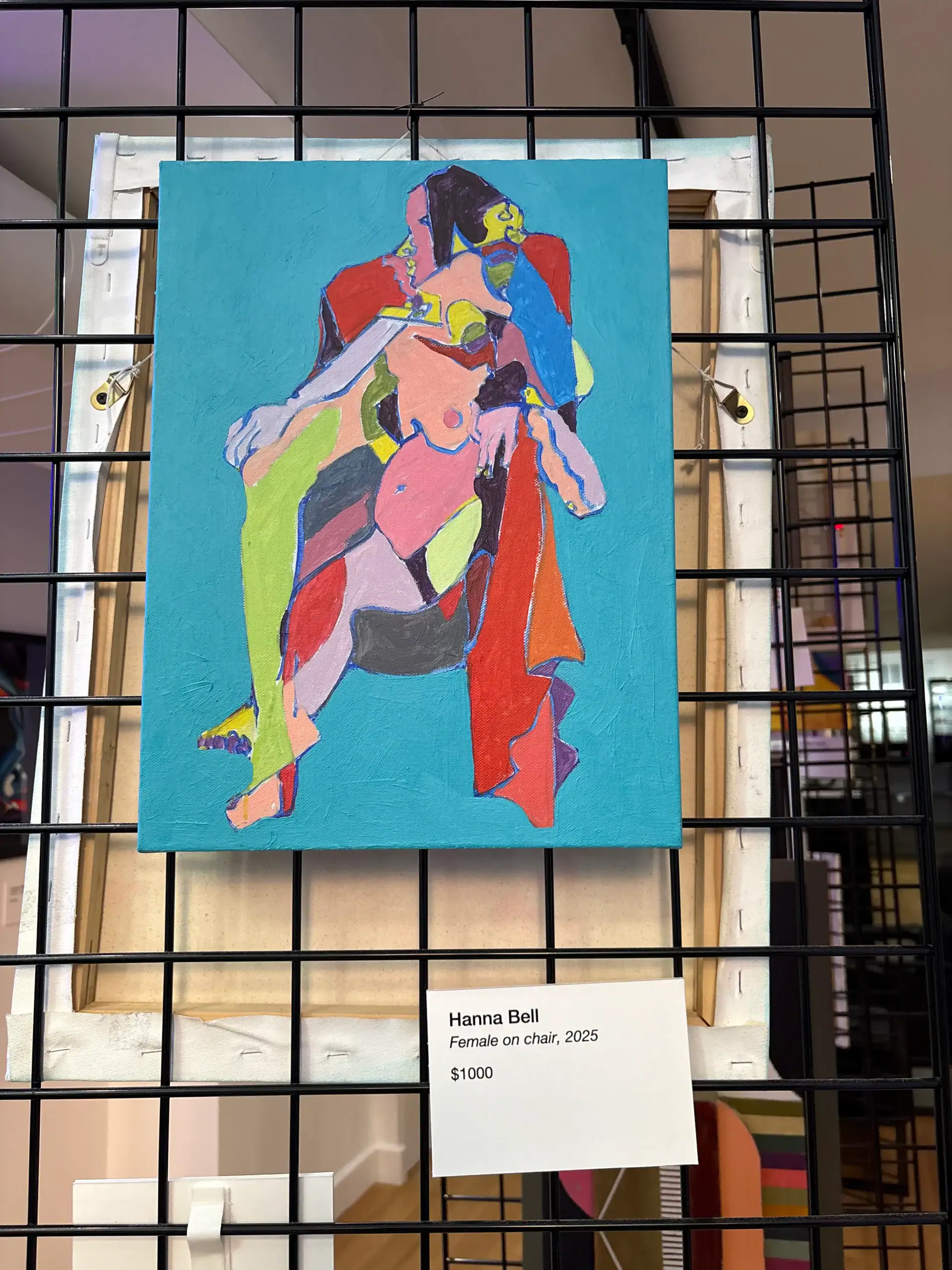 Colorful abstract painting of a woman on a chair displayed at NYC Wine Bar & Art Gallery with price tag.