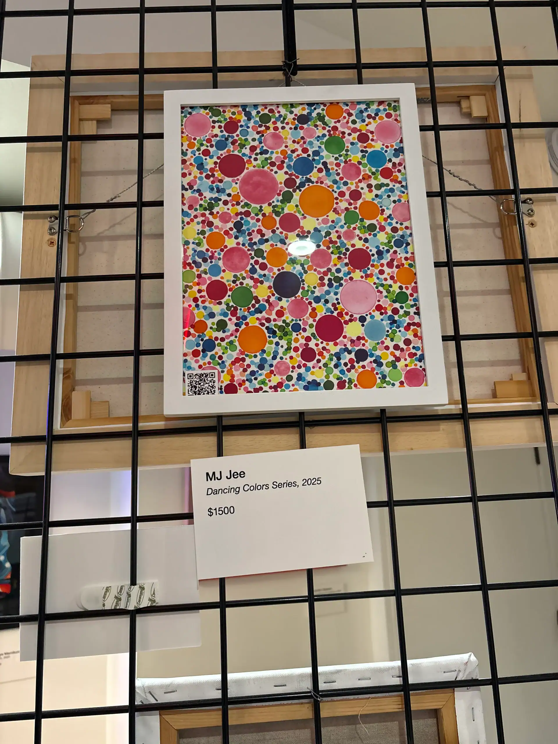 Colorful abstract artwork of circles on a black grid wall at a Wine Bar & Art Gallery in NYC.